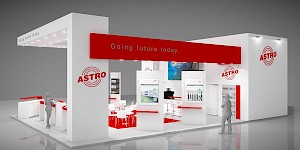CAD-Visualisierung: Frontalansicht eines Messestands für die Firma ASTRO in Weiß mit einer markanten roten Blende, auf der in grauer Schrift „Going future today." steht. Unter der Decke sorgen zahlreiche Einbauspots für eine helle Ausleuchtung. Auf den weißen Pfeilern prangt das rote ASTRO-Logo. Im Inneren mehrere Präsentationsstelen mit Bildschirmen und Produktgrafiken, dazwischen weiße Sitzmöbel und Stühle. Zwei graue Personenfiguren geben den Maßstab an. CAD-Visualisierung erstellt von Torsten Kraus.