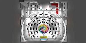 CAD-Visualisierung: Aufsicht von oben auf einen Messestand für das Land Ecuador, Auftritt von ProEcuador. Über dem Stand spannt sich ein rechteckiges Traversengerüst mit zahlreichen Scheinwerfern. Halbkreisförmig angeordnete Beratungsplätze mit weißen Tischen und schwarzen Stühlen umgeben ein zentrales kreisrundes Bodenelement in Regenbogenfarben. Am Rand liegen abgetrennte Räume, einer davon mit roter Wand. CAD-Visualisierung erstellt von Torsten Kraus.