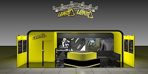 CAD-Visualisierung: Frontalansicht eines Messestands für die Firma Leatt in Gelb und Schwarz. Über dem Stand hängt eine dreieckige Traverse mit Scheinwerfern und zwei gelben LEATT-Logos mit Dreieck-Motiv. Die gelb-schwarze Rückwand zeigt großformatige Actionfotos eines BMX-Fahrers, eines Motorrads, eines Mountainbikers sowie einer Protektorenweste. Links an der gelben Wand das LEATT-Logo neben einer Tür. In der Mitte eine schwarze Theke mit gelber Deckplatte und schwarzen Barhockern, rechts eine schwarze Sitzecke. Seitliche Leuchttafeln zeigen Produktinformationen, der Boden ist gefliest. CAD-Visualisierung erstellt von Torsten Kraus.