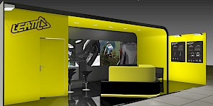 CAD-Visualisierung: Perspektivische Ansicht eines Messestands für die Firma Leatt in Gelb und Schwarz. Links eine gelbe Wand mit dem LEATT-Logo und einer Tür, dahinter eine dunkle Rückwand mit Actionfotos eines Motorrads, eines Mountainbikers und einer Protektorenweste. In der Mitte eine schwarze Theke mit gelber Deckplatte und schwarzen Barhockern. Rechts eine gelbe Wand mit zwei schwarzen Produkttafeln zur 3DF-Technologie. Deckenspots beleuchten die Aufbauten, der Boden ist gefliest. CAD-Visualisierung erstellt von Torsten Kraus.